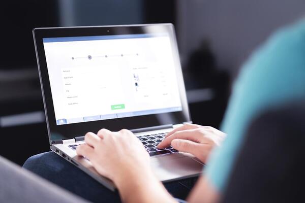 Adult reaching arms overhead in a bright room near a window